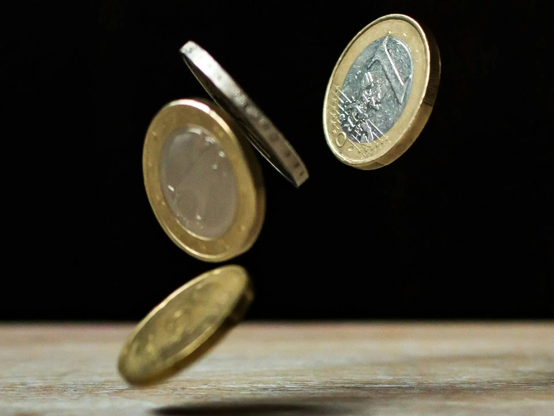 afbeelding van vier euro munten in vrije val